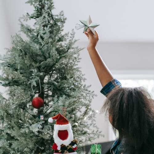 Child putting star on tree